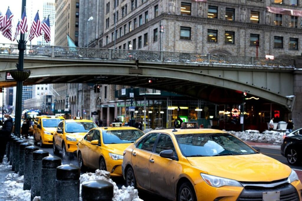 Melbourne cab service: A yellow taxi with the company logo on its side, parked on a busy street in Melbourne.